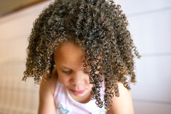 Not sure how to care for your child's gorgeous curls? With these 7 tips for curly hair care in kids learn how to maximize curl definition and embrace your child's naturally curly hair! #curlyhair #devacurl #biracialhair #mixedhair #curls