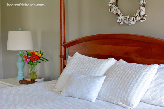 Farmhouse bedroom style. Isn't the cotton wreath beautiful above the poster bed?